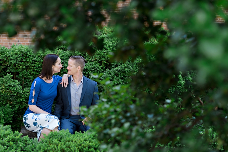An engaged couple sit in a garden in philadelphia.